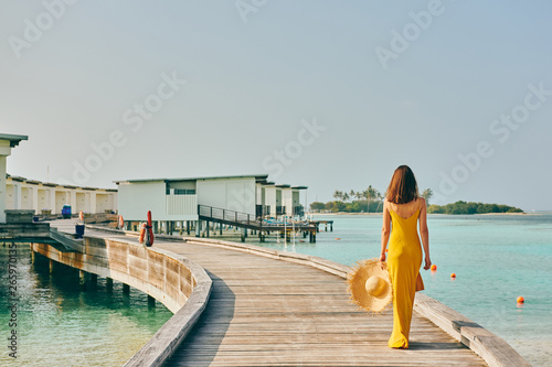 Woman in dress walking on tropical beach boardwalk © haveseen