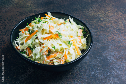 Traditional cole slaw salad in a black bowl photo