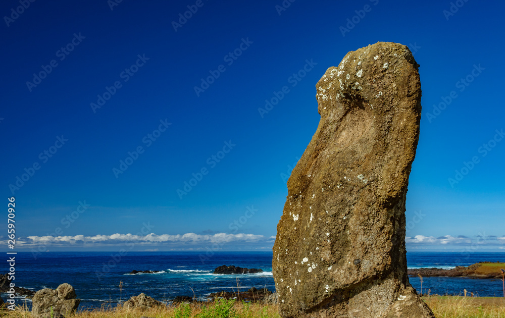 Isolated Moai against ocean with blue sky - Easter Island