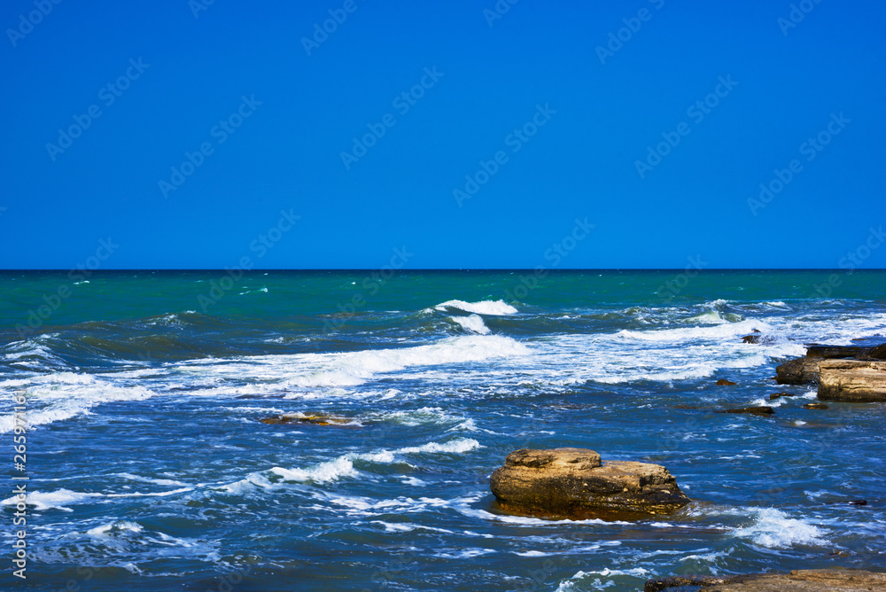 Rocky coastline with a cove and rock underwater, split view above water surface, Mediterranean sea, Spain. Azure sea, wave and blue sky. Seascape with sea horizon and clear deep blue sky. Rocky coastline with a cove and rock underwater, split view above water surface, Mediterranean sea, Spain. Azure sea, wave and blue sky. Seascape with sea horizon and clear deep blue sky.