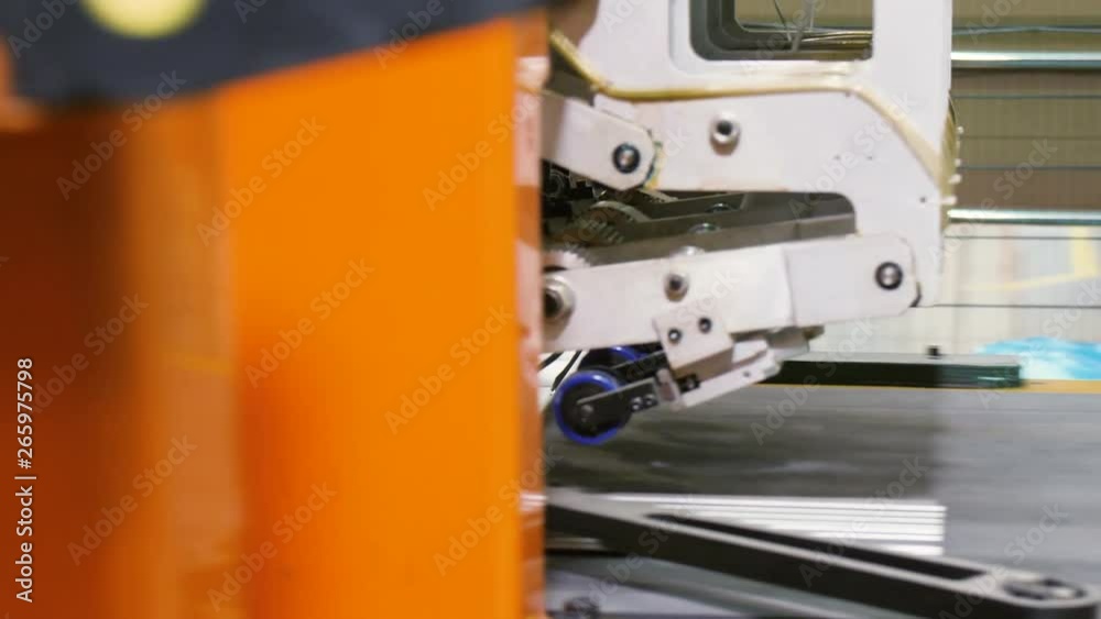 mechanism connects metal pipes to fridge panel on conveyor mechanism connects metal pipes to fridge panel on conveyor
