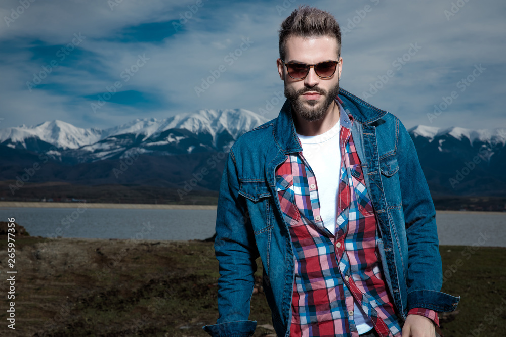 sexy young man in denim clothes and sunglasses standing outside sexy young man in denim clothes and sunglasses standing outside
