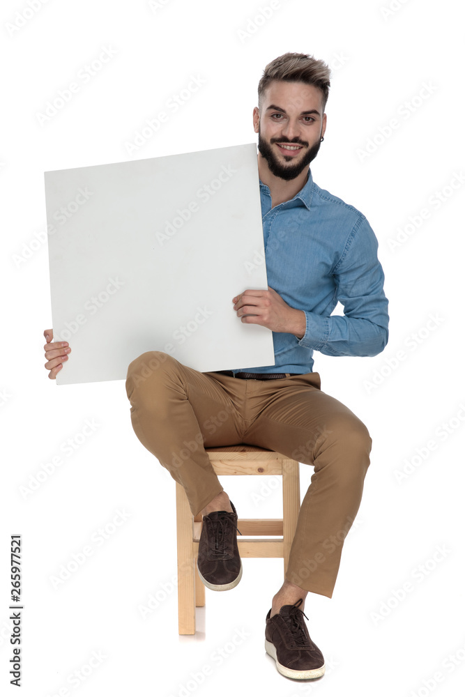 seated smiling man presenting a blank billboard seated smiling man presenting a blank billboard