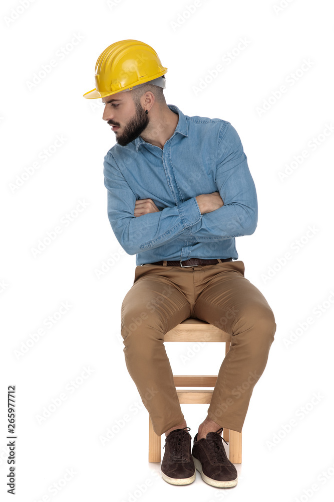 seated unshaved man looking close careful with arms folded seated unshaved man looking close careful with arms folded