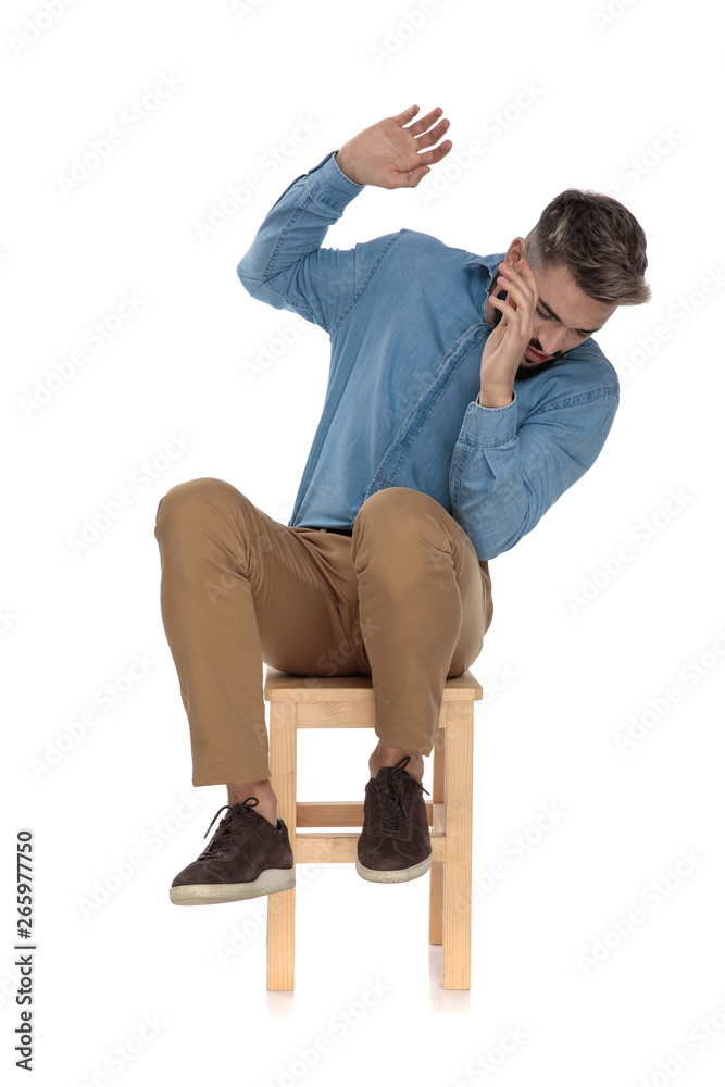 seated scared man in blue jeans shirt defending with hands seated scared man in blue jeans shirt defending with hands