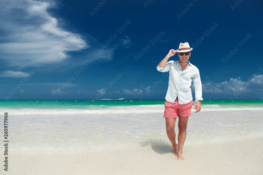 Obraz premium happy man sending his greetings while walking on the beach