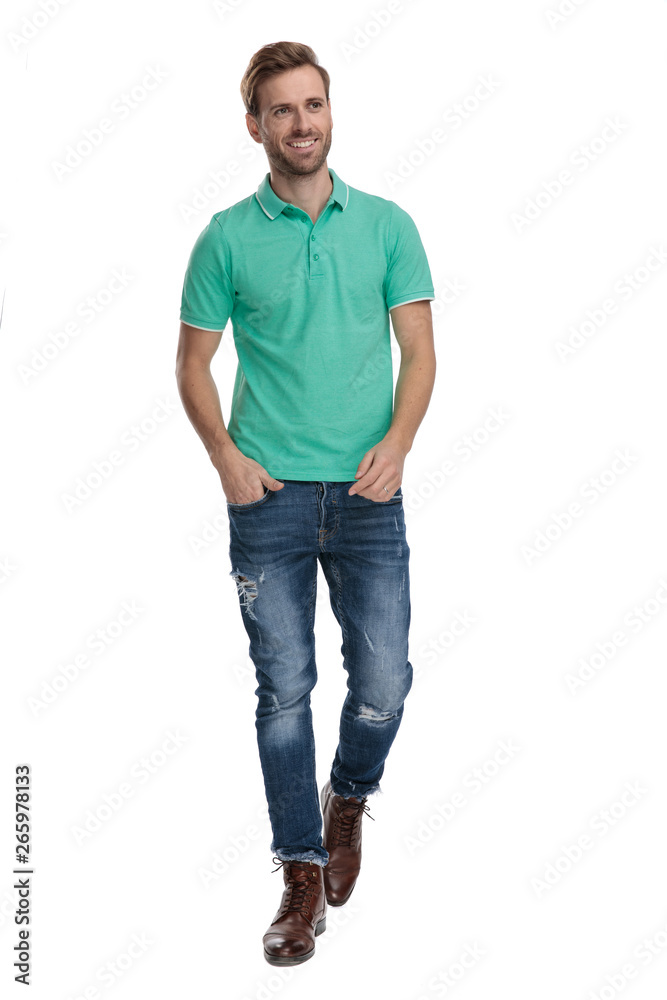 young man walking with hands in pockets while looking away young man walking with hands in pockets while looking away