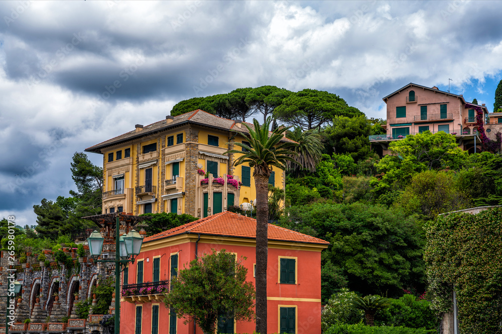 Morning view of Liguria landscape on coastline of mediterranean sea, Italy. View of the picturesque hill with luxury villas. Facades of villas in the lush garden.