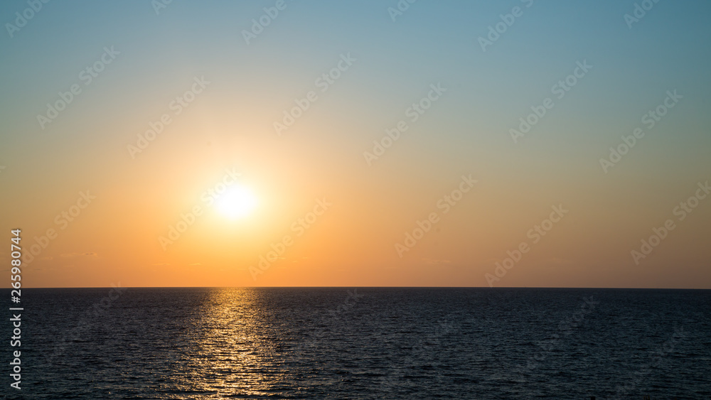 The setting sun and clear sky above the waters of the Black Sea