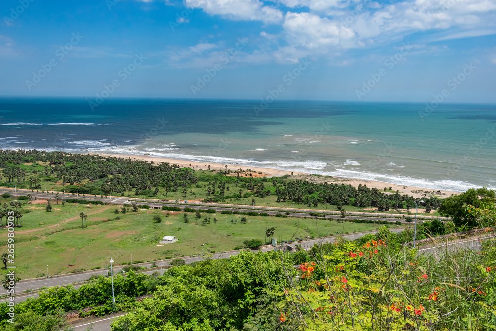 top view of sea beach road looking awesome from top of a mountain with blue sky & beautiful sea view.