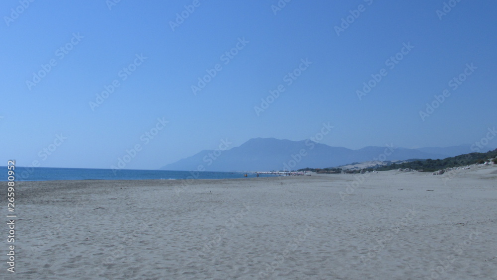 people walk along the beach along the sea enjoying the sun, the wave and the sound of water people walk along the beach along the sea enjoying the sun, the wave and the sound of water