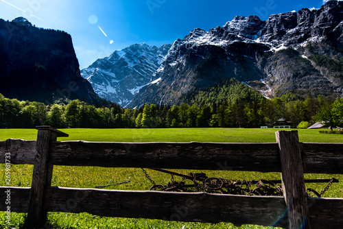 glade at the Koenigssee lake in the Alps, in Bavaria, view of the spring mountains, green trees and snow on the peaks