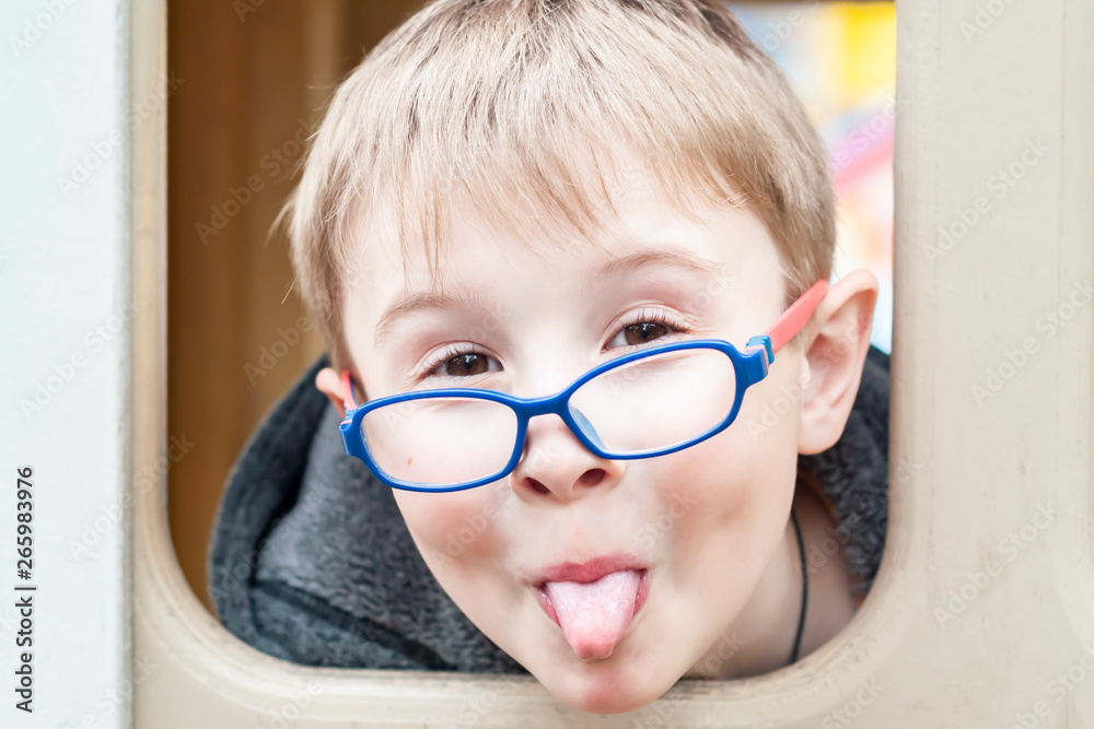 Cute gay boy stuck out his tongue. Beautiful little boy with glasses making  a face Stock-foto | Adobe Stock
