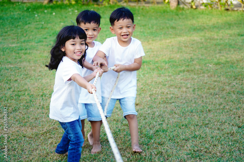 Kid teamwork and competition concept.  Children play tug of war with unity and teamwork.