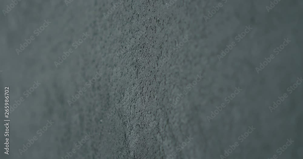 Slow motion shot of decorative dark concrete surface, shot handheld