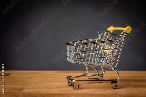 Empty shopping cart on wooden table.