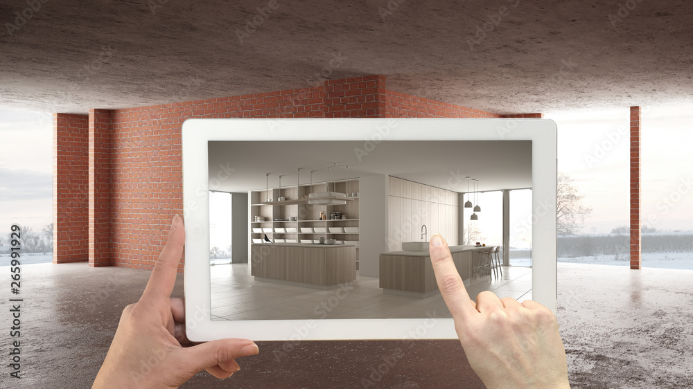 Augmented reality concept. Hand holding tablet with AR application used to simulate furniture and design products in interior construction site, modern white kitchen with island Augmented reality concept. Hand holding tablet with AR application used to simulate furniture and design products in interior construction site, modern white kitchen with island