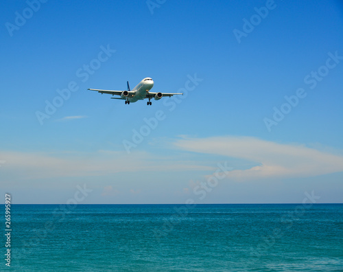 Airplane landing over the sand beach