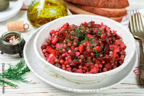 Vinaigrette is a traditional Russian and Ukrainian vegetable salad of beets, carrots, potatoes, pickles, green peas and dill. Vegetarian diet dish. Selective focus