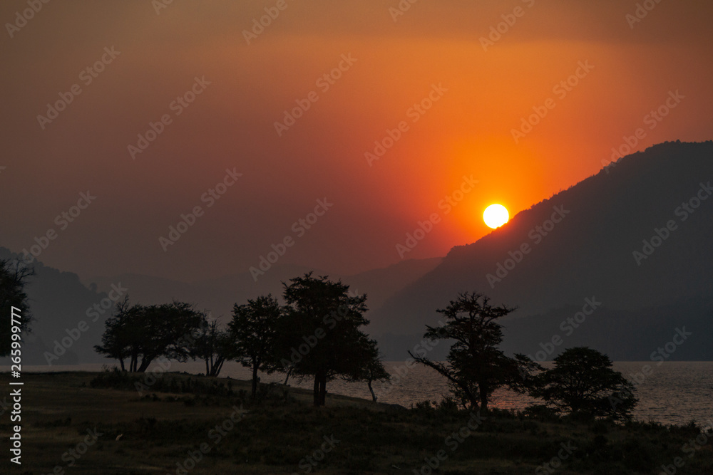 Atardecer junto a montañas y al lago icalma