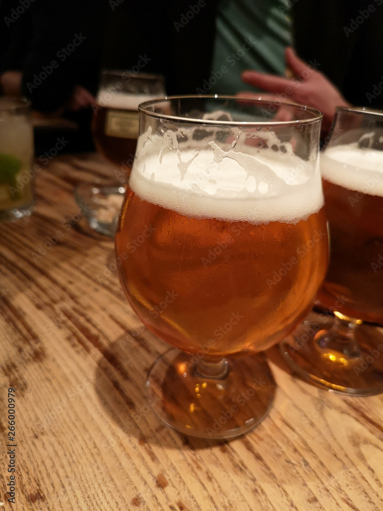 A glass of beer in a bar with friends