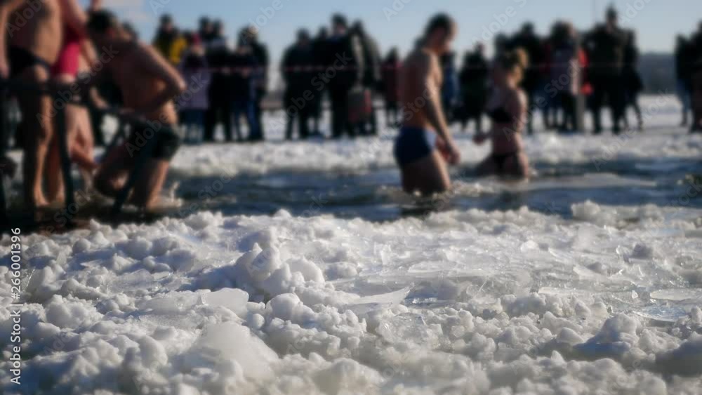 Bathing in cold ice water. Mass festive celebratory hardening, winter swimming in freeze. Shocked people bathe in ice hole. Christmas New Year holidays. Epiphany. Baptism of the Lord Bathing in cold ice water. Mass festive celebratory hardening, winter swimming in freeze. Shocked people bathe in ice hole. Christmas New Year holidays. Epiphany. Baptism of the Lord