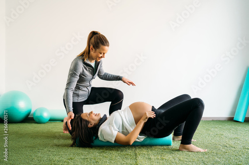 Fotografía Pregnant woman doing fitness ball and pilates exercise with coach