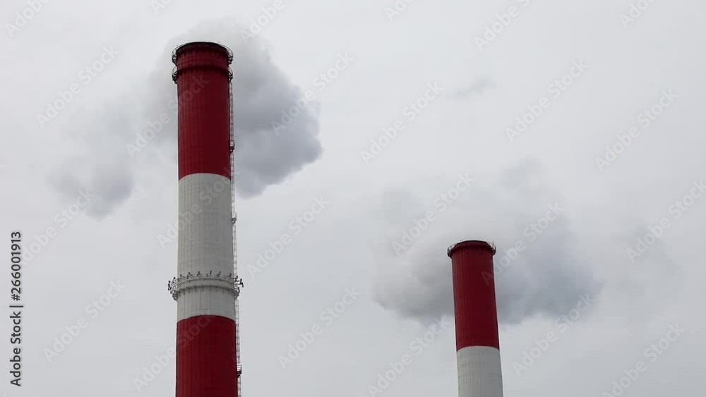 Two red smoking pipes on the background of Cloudy sky Two red smoking pipes on the background of Cloudy sky
