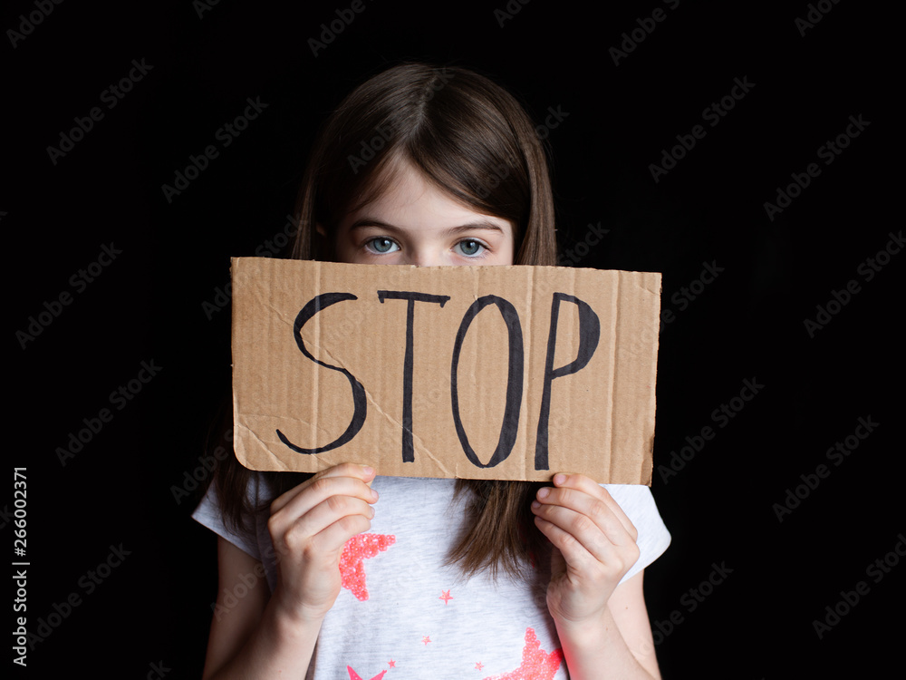 sad preteen girl holding a sign stop, concept of problems, negative