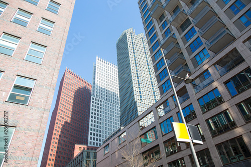 Low angle downtown glass and concrete skyscrapers against a blue sky background
