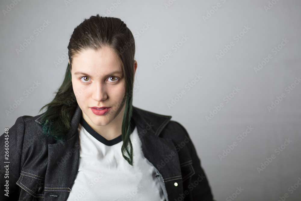 Beautiful brunette girl with dyed green hair on white background.