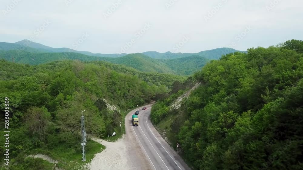 Aerial fly over Caucasian mountains and winding road with cars Aerial fly over Caucasian mountains and winding road with cars