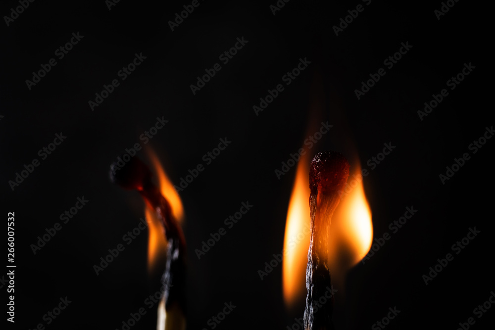 Matches close-up on a dark background. Fire burning in the dark, light in a philosophical concept. Macro photo. Matches close-up on a dark background. Fire burning in the dark, light in a philosophical concept. Macro photo.