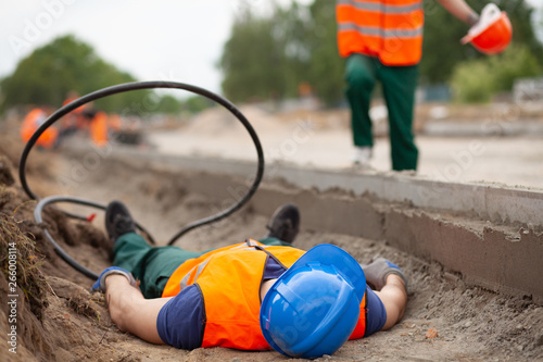 Closeup of injured road construction worker lying on the ground