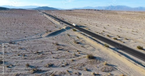 RV Fifth Wheel Driving On California Desert Road - Wide Rear Aerial View Drone Shot