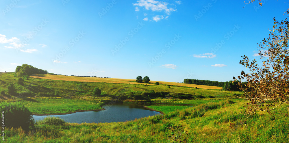 Sunny summer landscape with river,green hills and fields