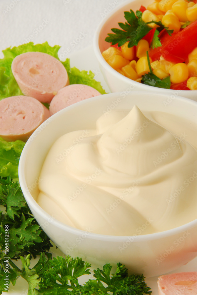 Ceramic dip bowl full of mayonnaise, sausages, parsley, isolated on white background Ceramic dip bowl full of mayonnaise, sausages, parsley, isolated on white background
