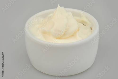 Mayonnaise in a bowl on an isolated gray background