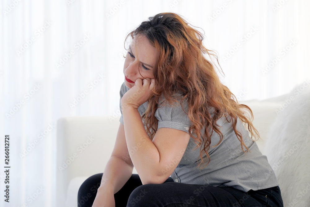 Lonely woman is sad sitting on the bed. Portrait of a beautiful sad girl closeup. Woman feel depression.