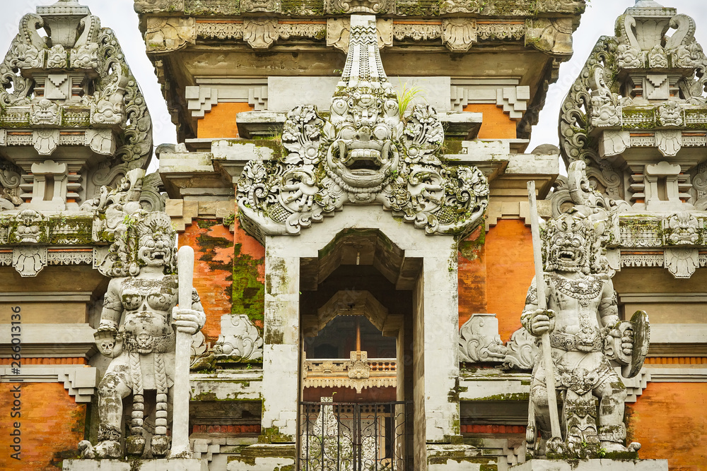 Balinese style hinduist stone temple decorated with statues of demons in Jakarta, Indonesia, Java island.