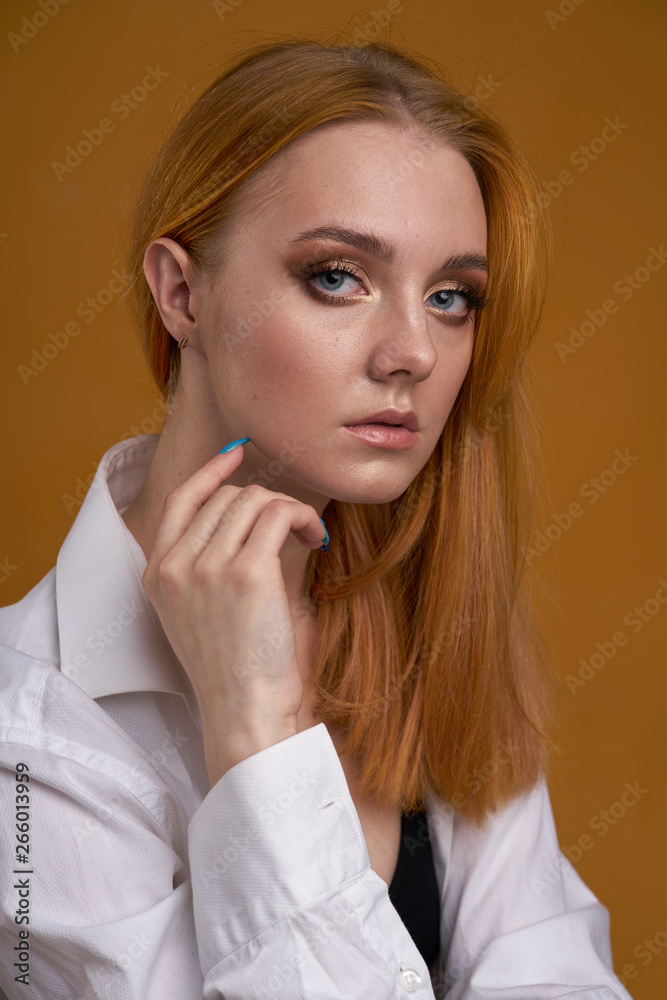 Stylish young girl with curly hair, smiling cutely, posing, on yellow background Stylish young girl with curly hair, smiling cutely, posing, on yellow background