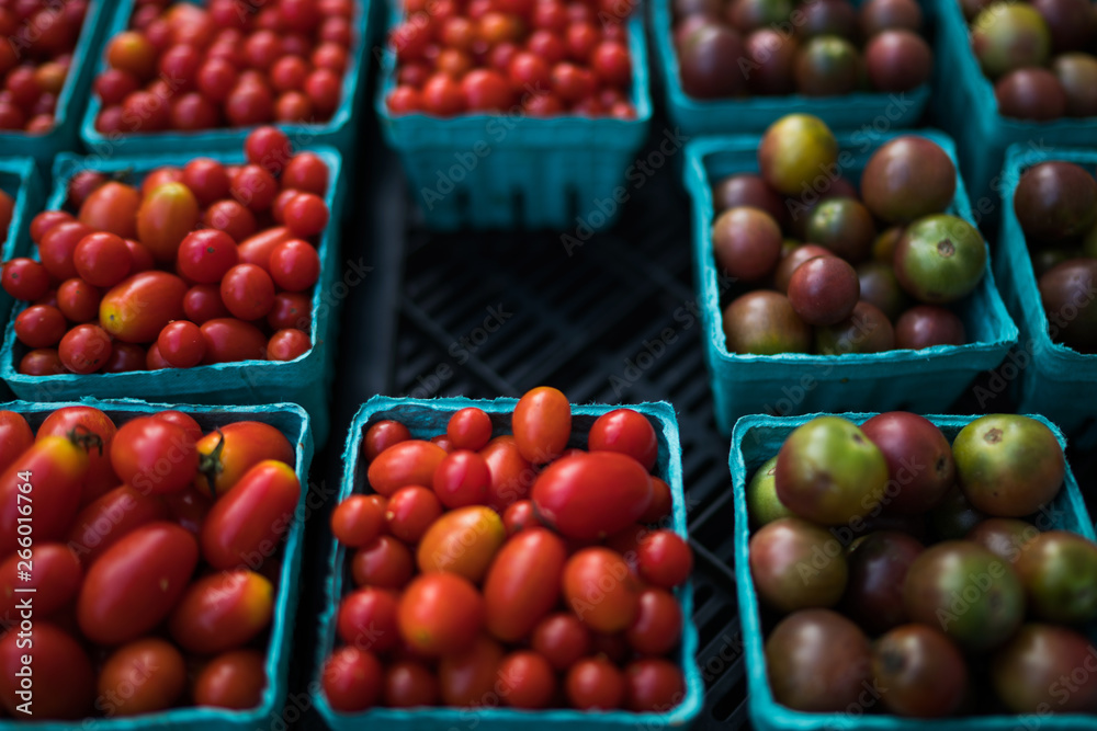 Fresh tomatoes on farmers market, California, USA. Pint baskets of organic colorful tomatoes on the counter at a farmers market. Organic vegetable stall. Selling fresh vegetables. Bio and eco food. Fresh tomatoes on farmers market, California, USA. Pint baskets of organic colorful tomatoes on the counter at a farmers market. Organic vegetable stall. Selling fresh vegetables. Bio and eco food.