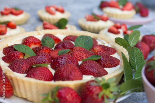 Tart with strawberries and whipped cream decorated with mint leaves