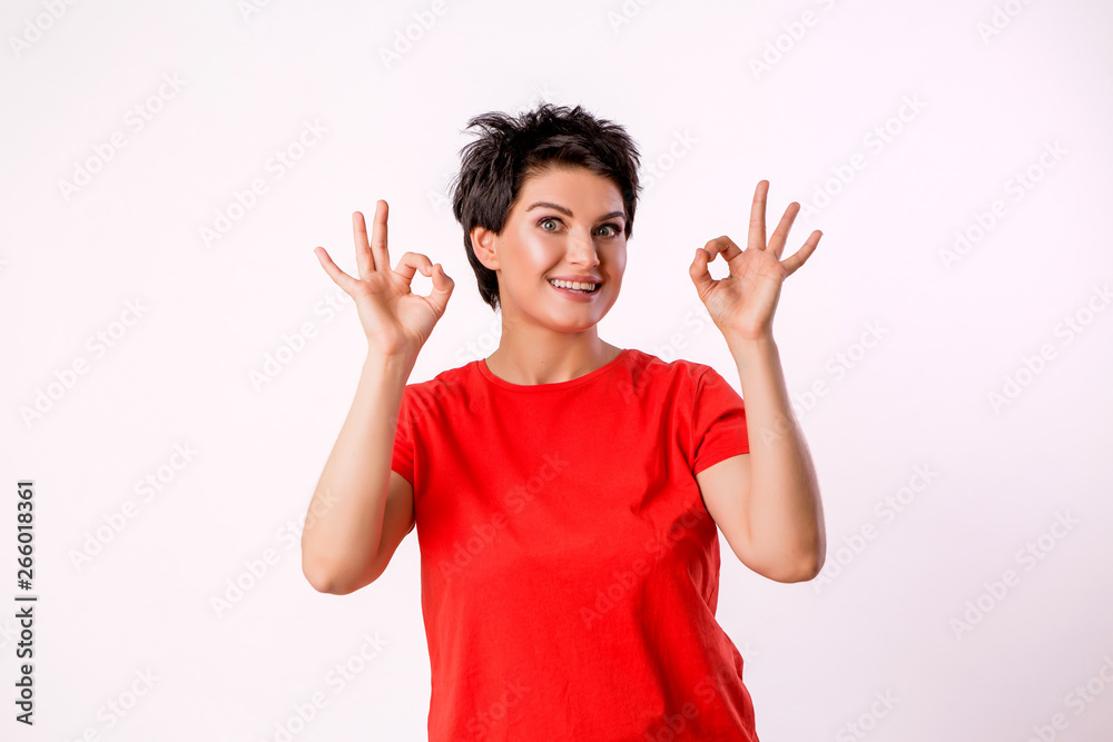 Human emotions and feelings.People, youth and happiness.charming young woman model smiling widely with her white straight teeth while holding her hands to her face posing in the Studio Human emotions and feelings.People, youth and happiness.charming young woman model smiling widely with her white straight teeth while holding her hands to her face posing in the Studio