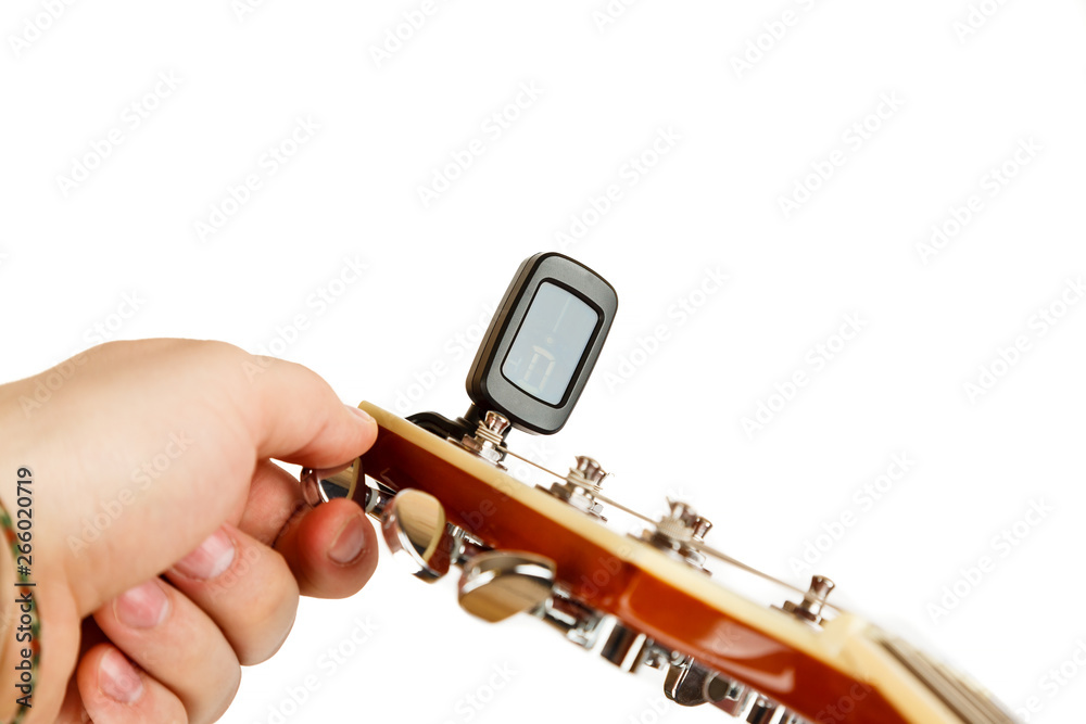 Fototapeta Hand tuning acoustic guitar with electronic tuner