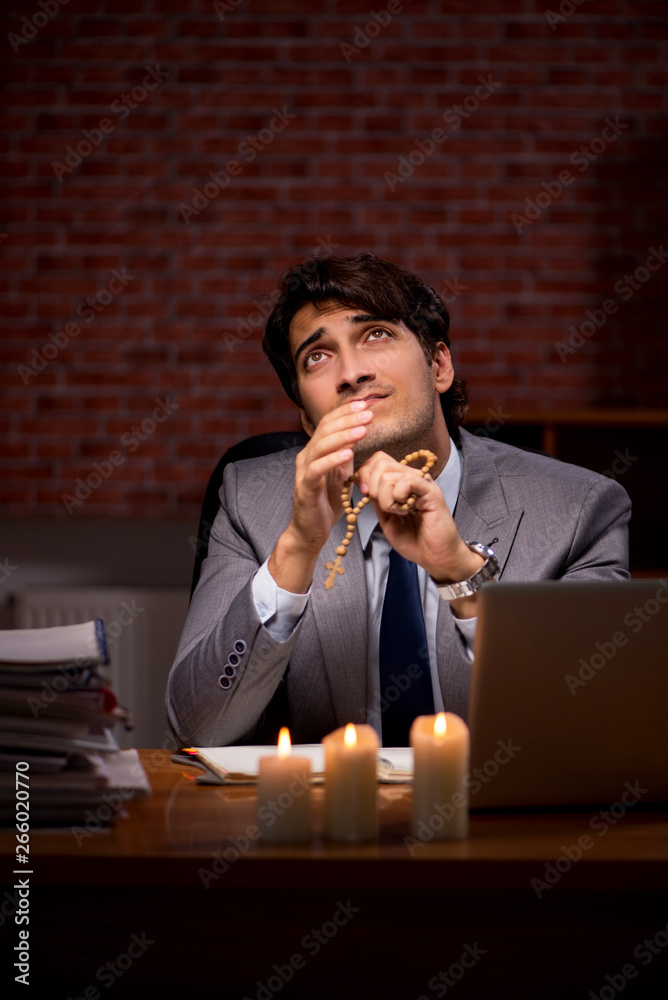 Businessman working late in office with candle light Businessman working late in office with candle light