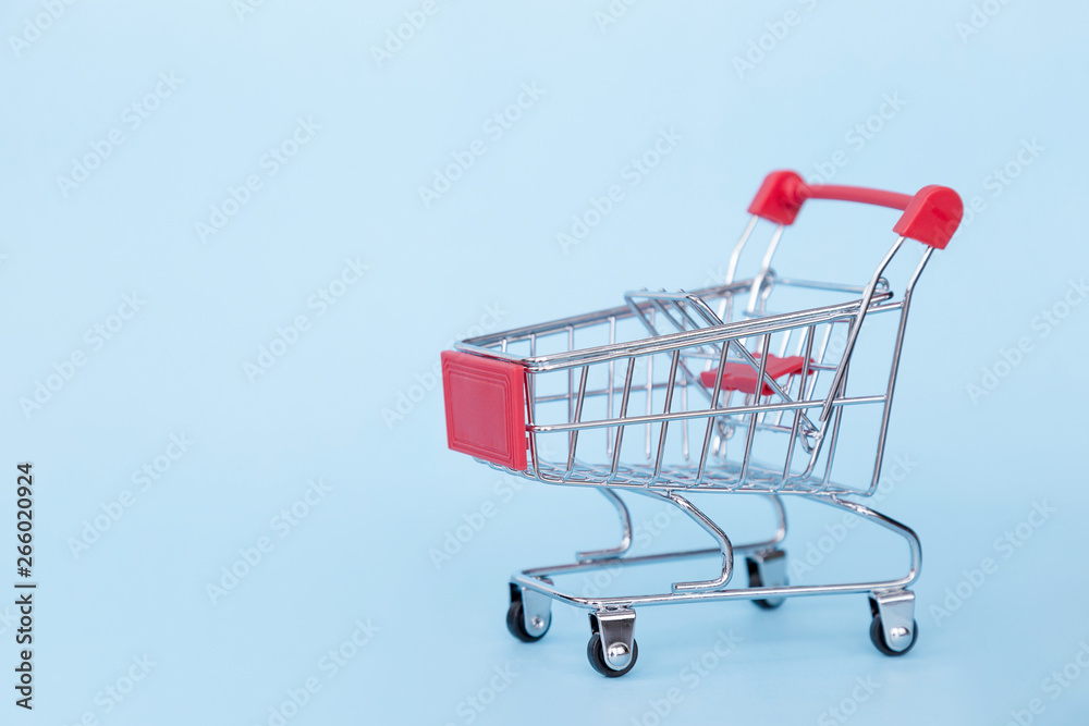 Empty grocery cart on wheels on a blue background