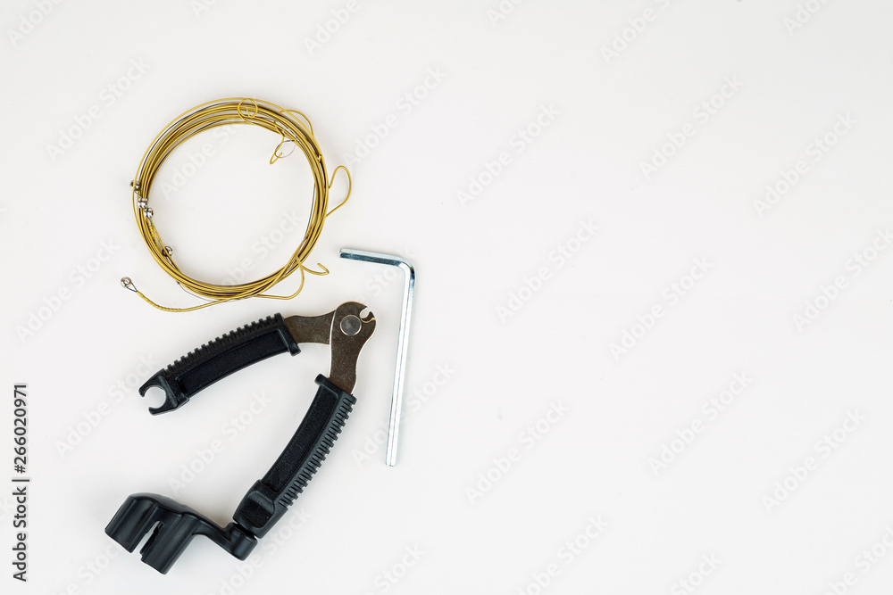 Tools for acoustic guitar strings change on a white background, top view Tools for acoustic guitar strings change on a white background, top view