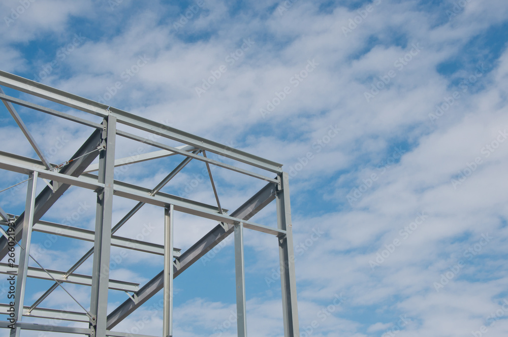 Metal frame of the new building against the blue sky with clouds