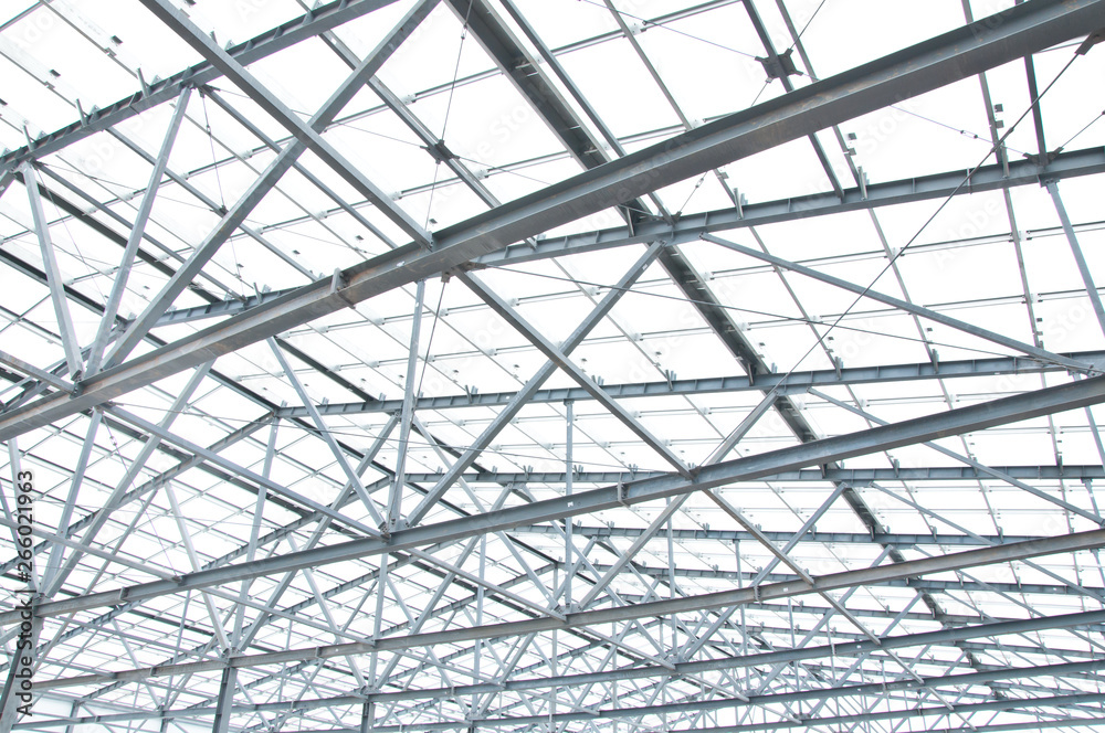 Metal frame of the new building against the blue sky with clouds